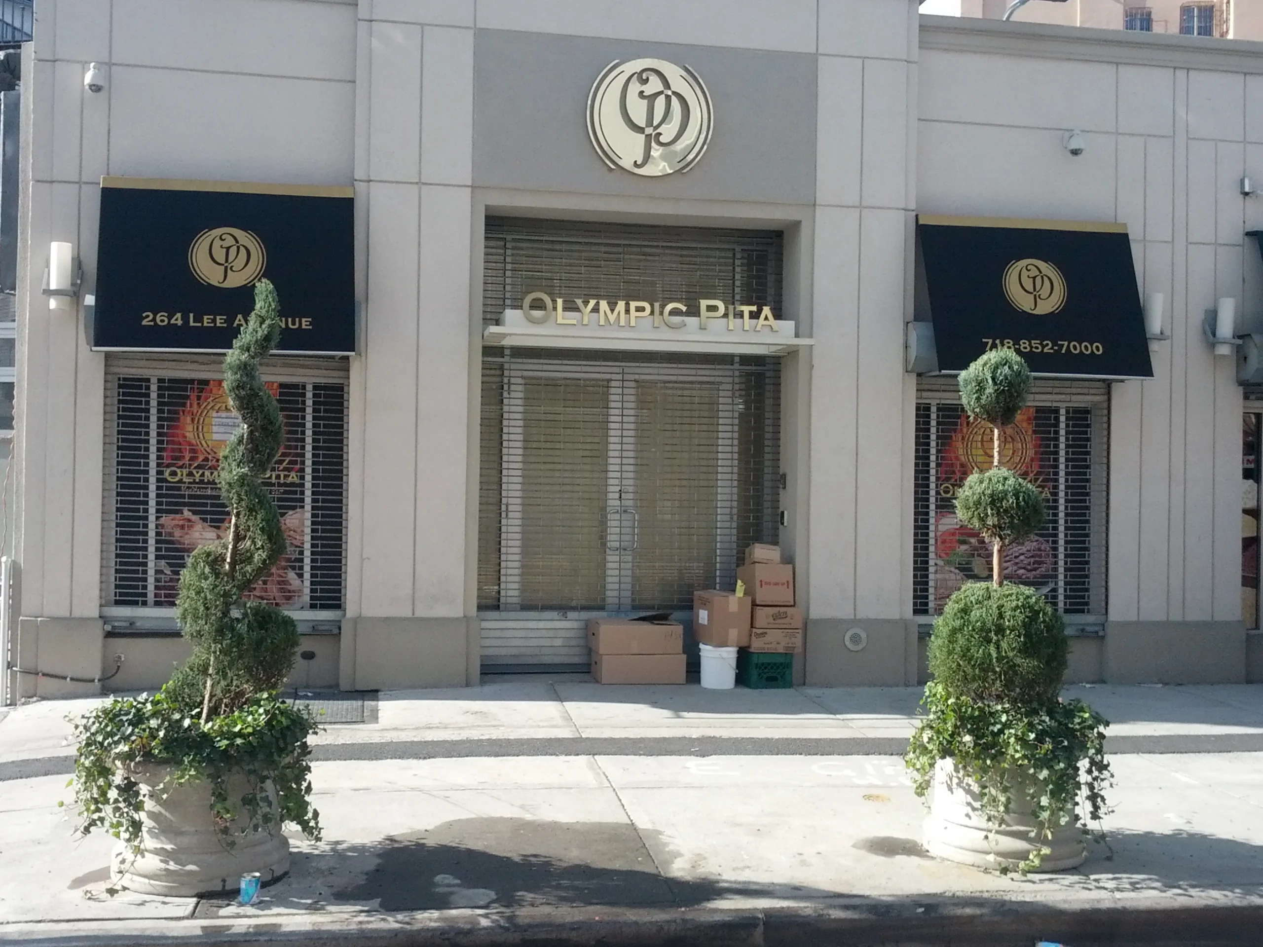metal signage and black business awnings olympic pita